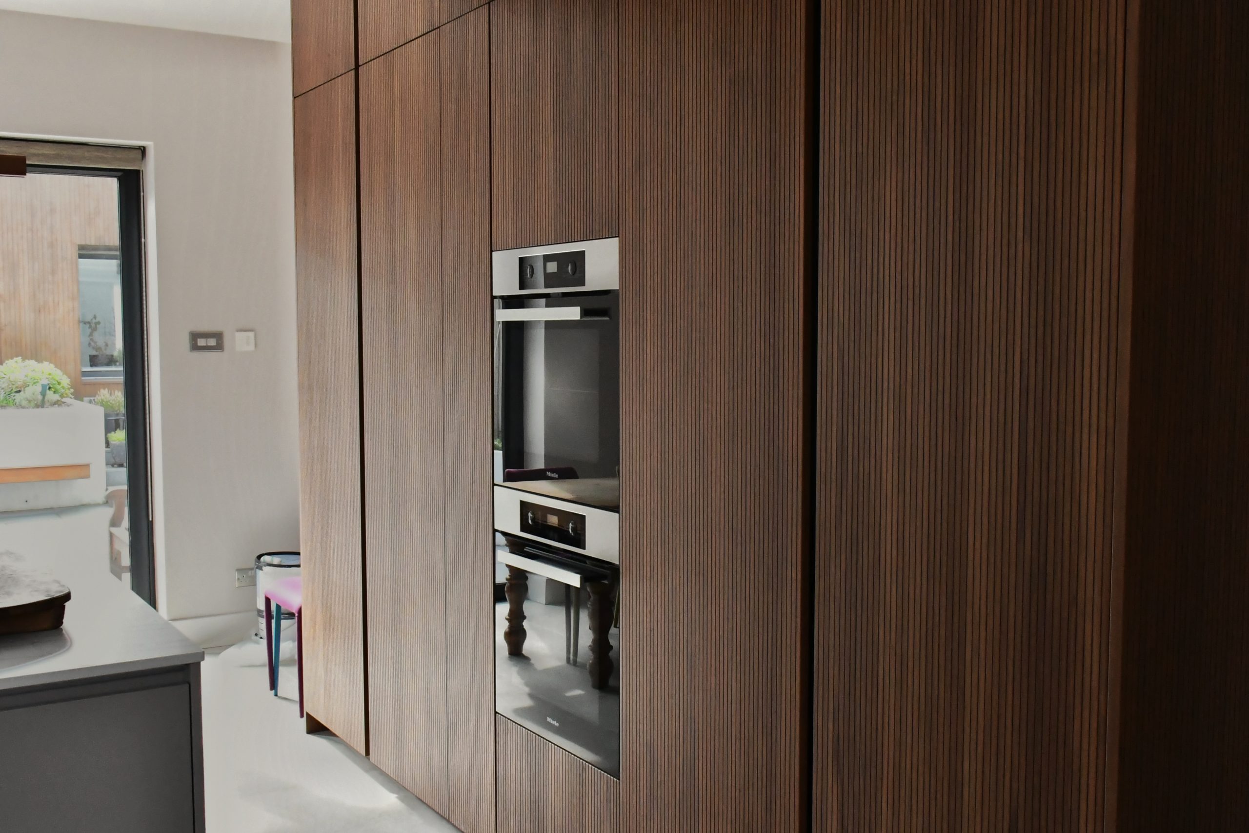 Memory RI Walnut wall with integrated Siemens ovens set into full-height cabinetry