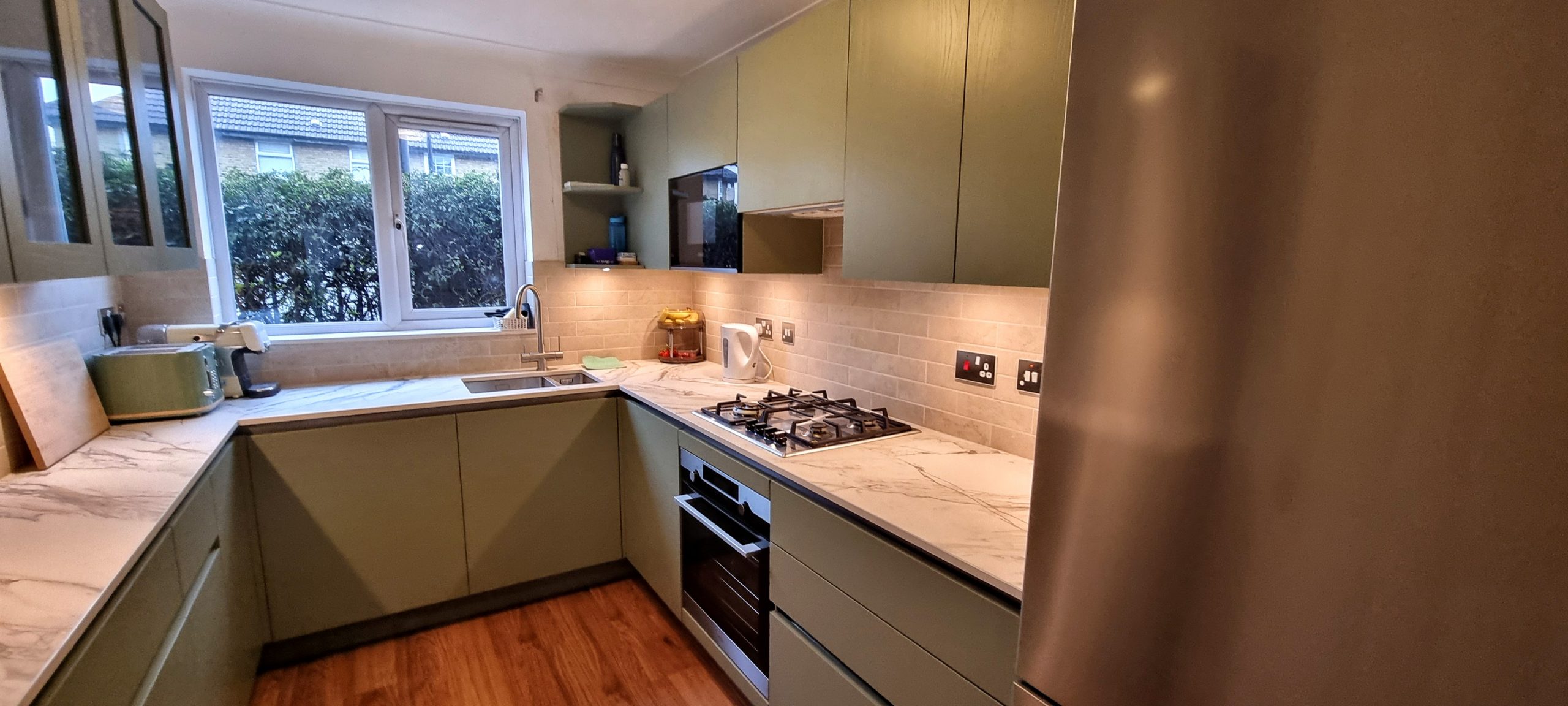 Bespoke lacquered sage green modern handleless kitchen designed and installed by Victoria Kitchens, Greenwich, SE London