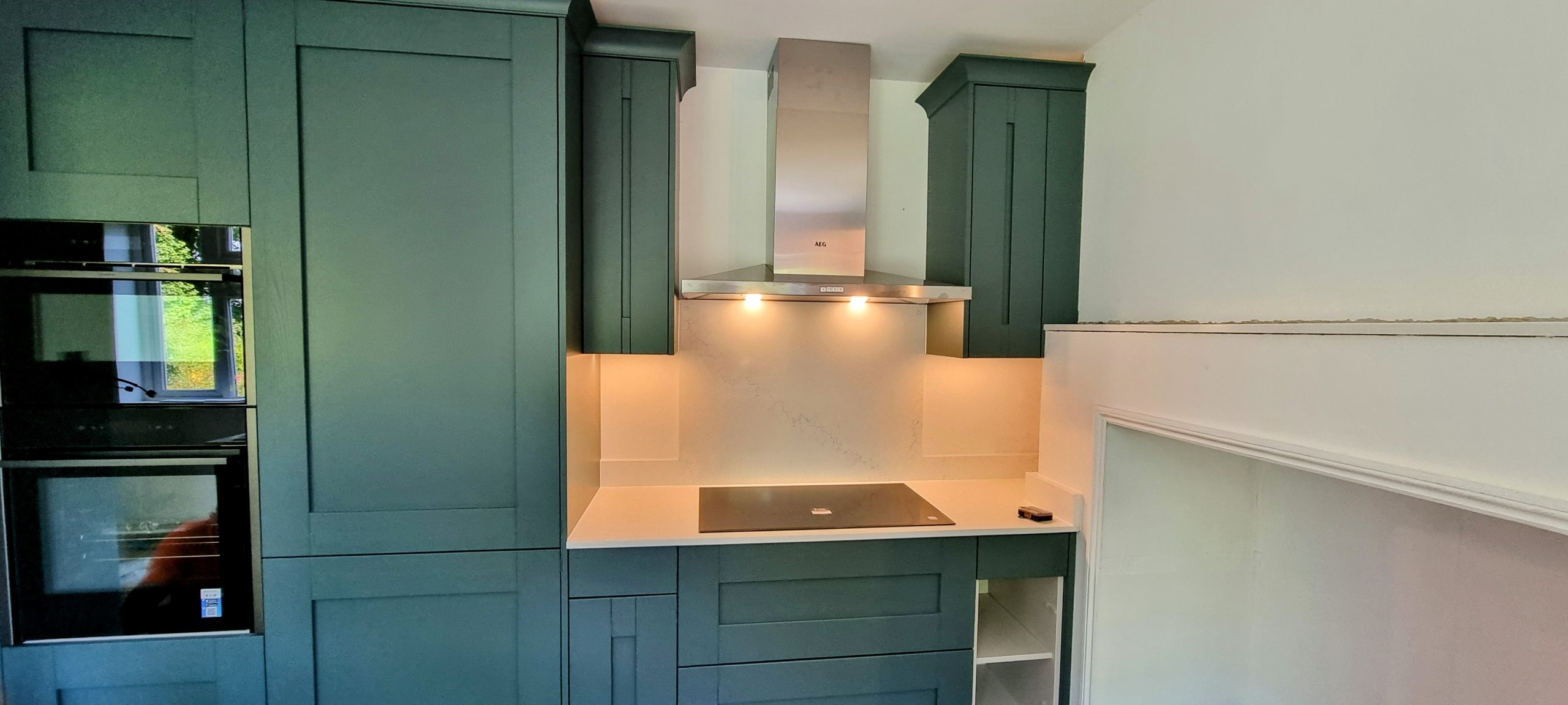 Sage green Caledonia handleless shaker kitchen with painted cabinetry, Victoria Kitchens