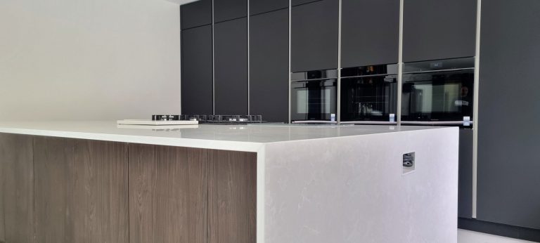 Carbon anti-fingerprint dark matt kitchen with wood-effect accents and open-plan layout, Bexley, Victoria Kitchens