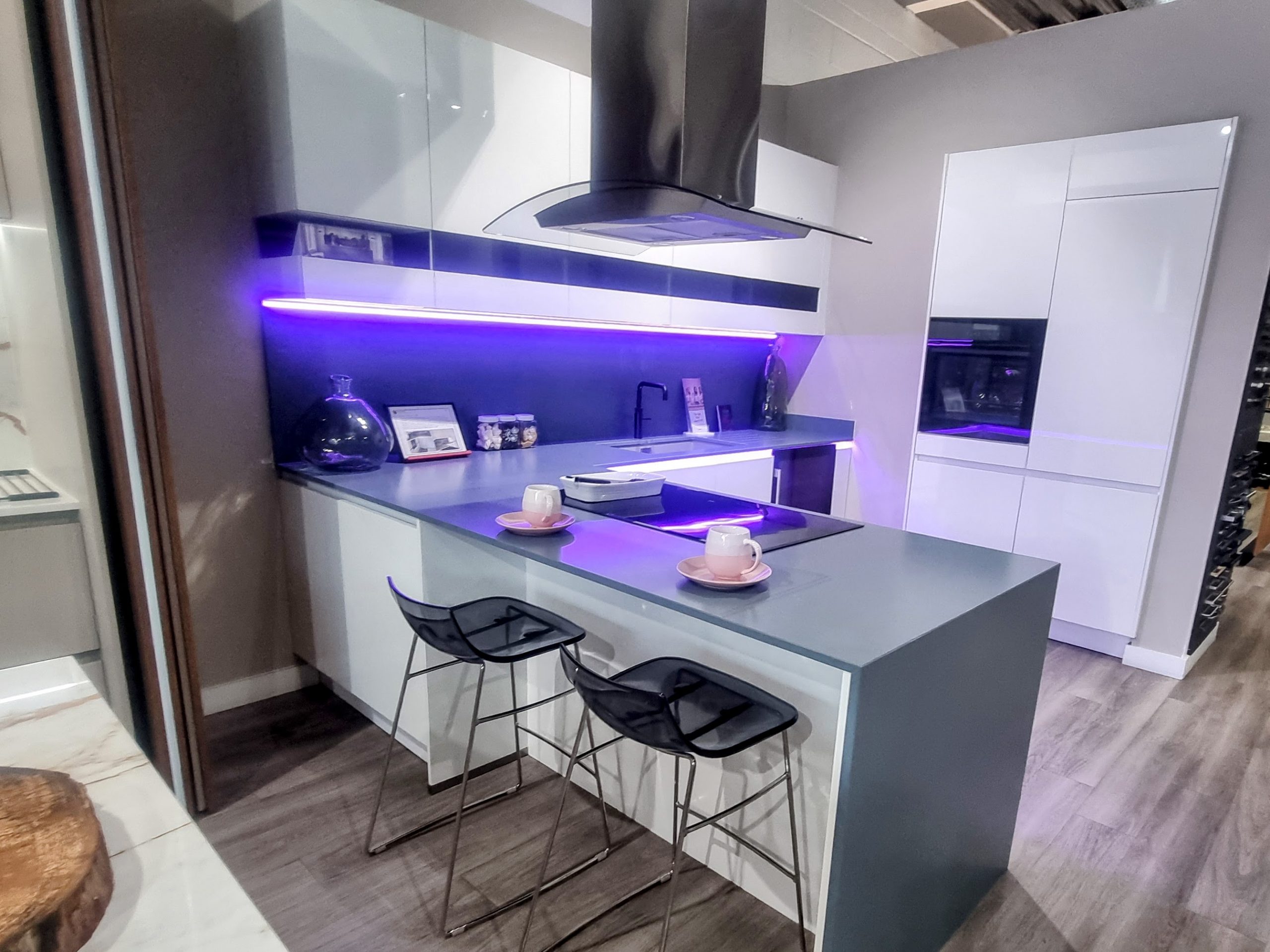 White gloss handleless kitchen with layered under-cabinet and ceiling lighting, Victoria Kitchens, Greenwich SE7