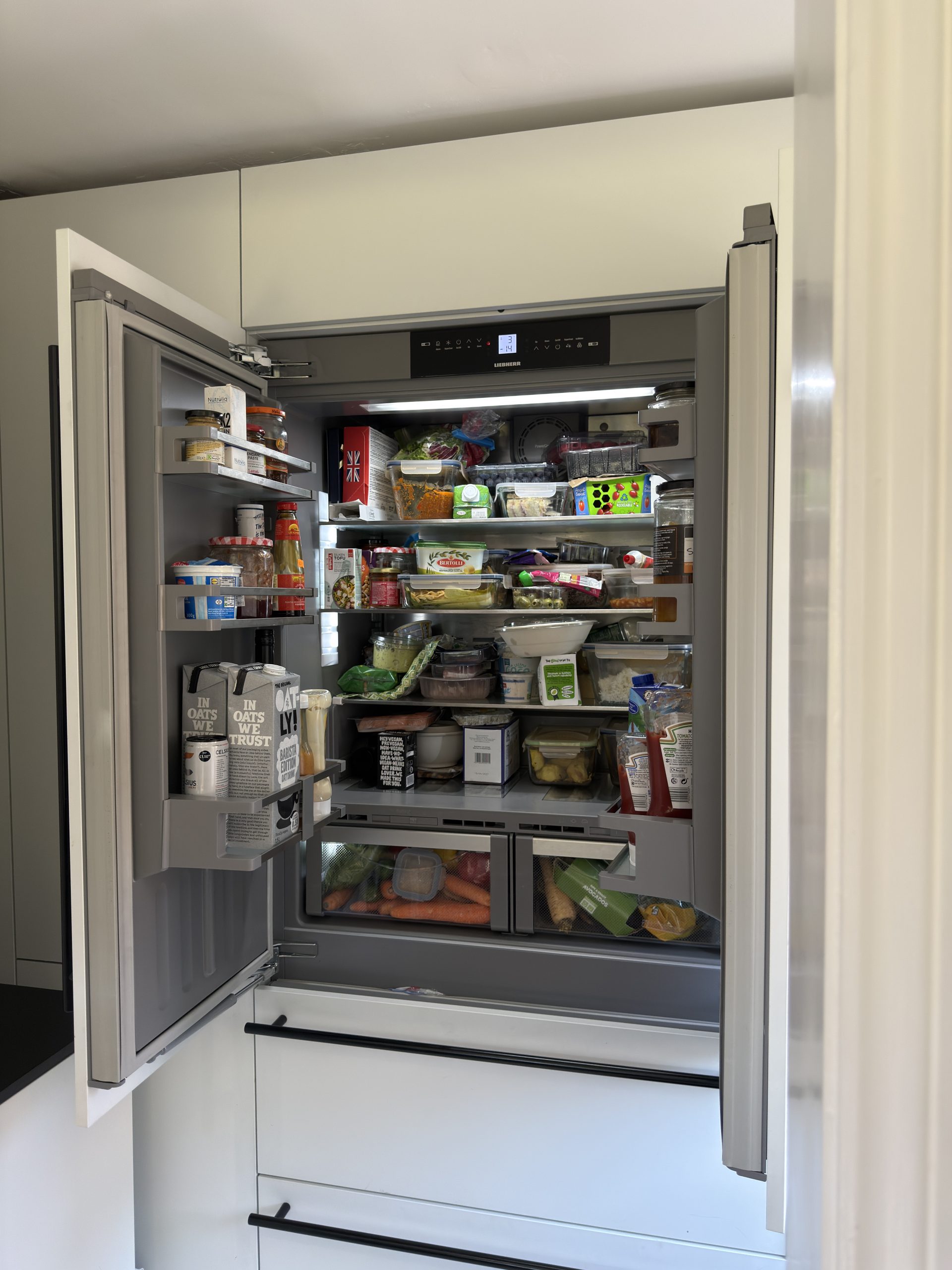 Integrated appliances and handleless cabinetry in a modern bespoke kitchen