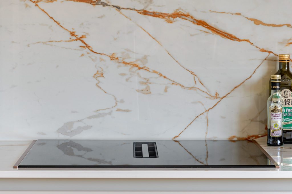 Close-up of Neff hob with integrated extractor set into Dekton worktop, Rotpunkt kitchen, Victoria Kitchens