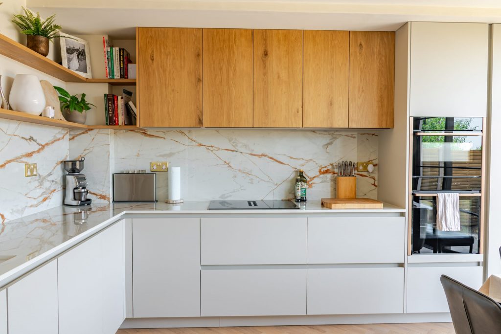 Full room view of contemporary Rotpunkt cashmere kitchen with oak veneer cabinetry, Dekton worktops and Neff appliances, Victoria Kitchens