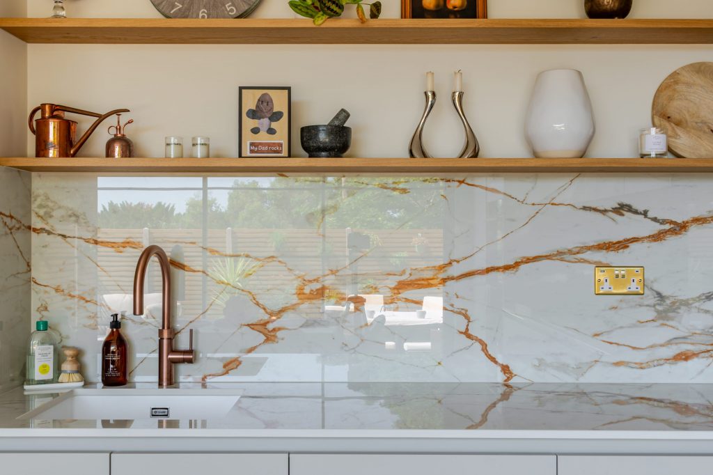 Straight-on shot of Quooker tap and Caple sink with Dekton worktop, splashback and floating shelving, Rotpunkt kitchen, Victoria Kitchens