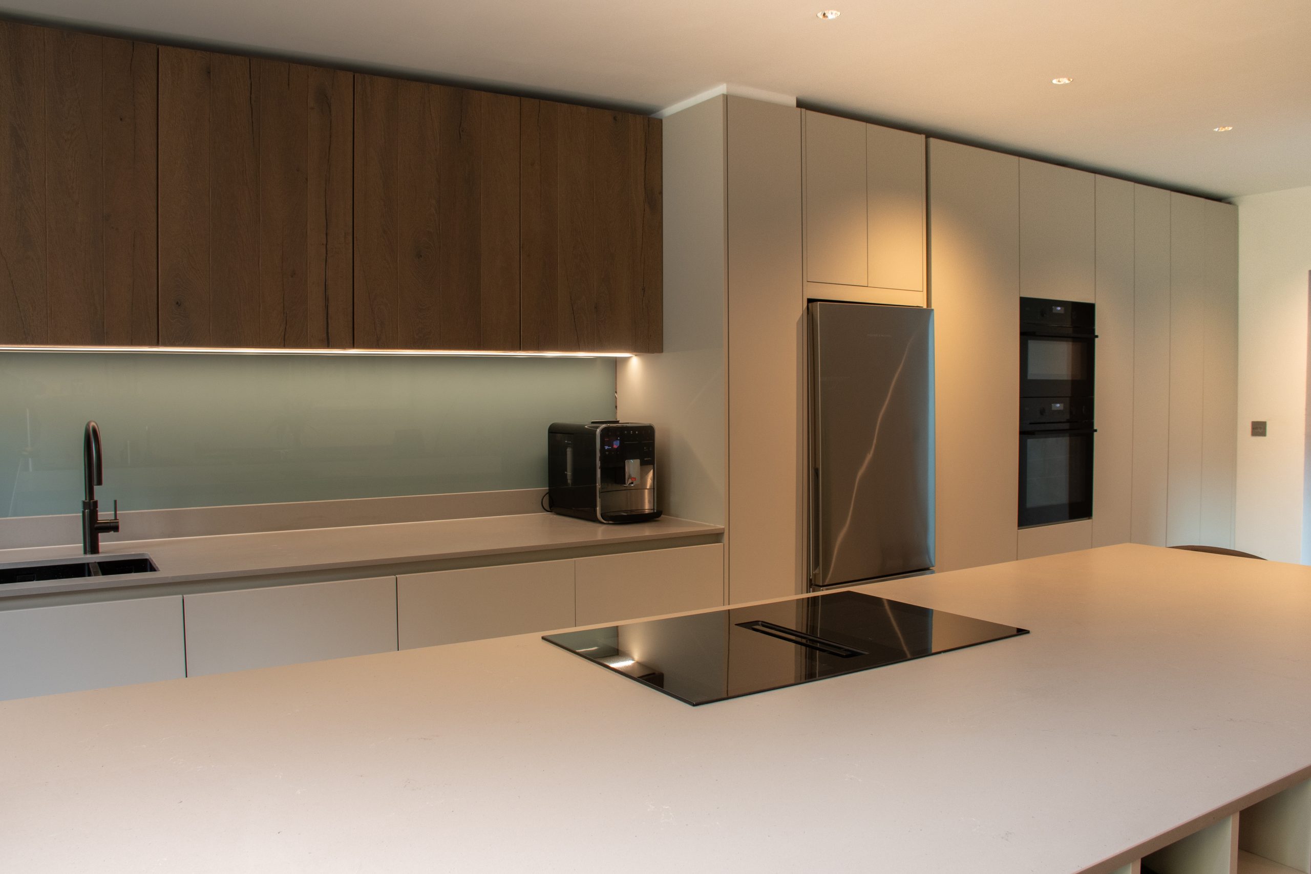 Rotpunkt kitchen island with integrated fridge, ovens, tap and Kashmir Matt cabinetry, designed by Bernard McGettigan, Victoria Kitchens