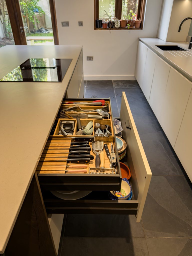 Kitchen island drawer open showing double pull-out internal drawers, Rotpunkt Kashmir Matt cabinetry, Victoria Kitchens