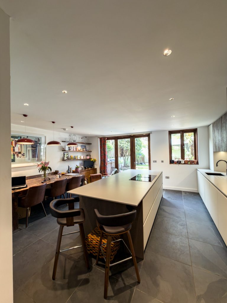 Second wide view of Rotpunkt Kashmir Matt kitchen with sandblasted timber accents, generous island and integrated appliances, SE London