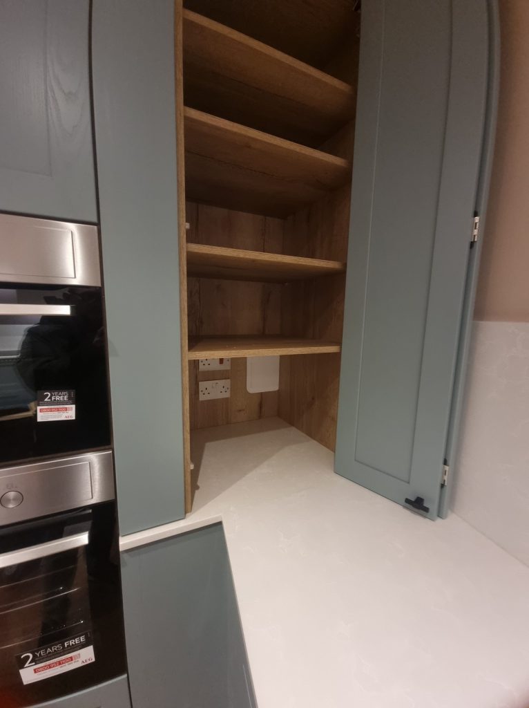 Interior of shaker kitchen cabinet showing empty solid oak shelves, Victoria Kitchens